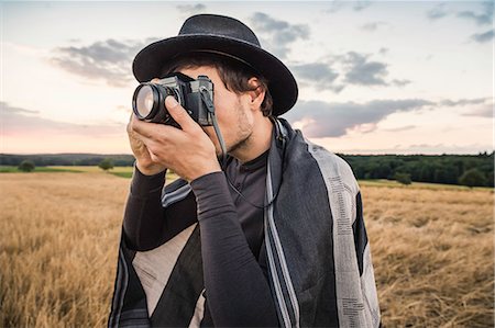 simsearch:649-08924658,k - Mid adult man, standing in field, taking photograph with SLR camera, Neulingen, Baden-Württemberg, Germany Fotografie stock - Premium Royalty-Free, Codice: 649-08922744