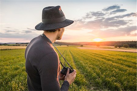 simsearch:649-08895049,k - Portrait of mid adult man, standing in field, holding SLR camera, looking at view, Neulingen, Baden-Württemberg, Germany Photographie de stock - Premium Libres de Droits, Code: 649-08922742