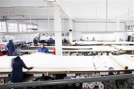 Female factory workers unrolling textiles in clothing factory Stock Photo - Premium Royalty-Free, Code: 649-08922772