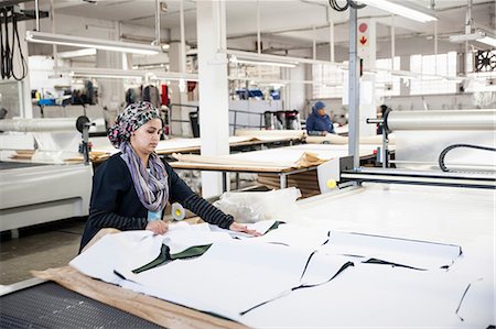 simsearch:614-08926148,k - Factory worker removing cut textile pattern from pattern cutting machine in clothing factory Foto de stock - Royalty Free Premium, Número: 649-08922784