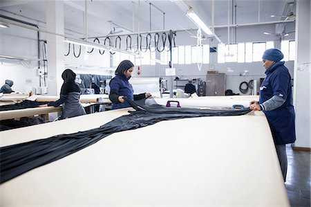 simsearch:614-08926148,k - Factory workers unrolling textiles on work table in clothing factory Foto de stock - Royalty Free Premium, Número: 649-08922787