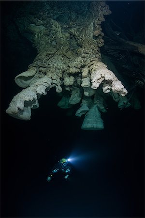 simsearch:649-09208950,k - Scuba diver exploring unique natural formations known as "bells" in submerged caves beneath the jungle Fotografie stock - Premium Royalty-Free, Codice: 649-08922791