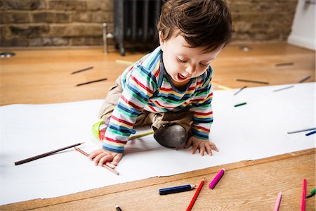 simsearch:614-06896952,k - Male toddler sitting on floor drawing on long paper Foto de stock - Sin royalties Premium, Código: 649-08922820