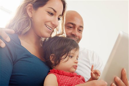 simsearch:614-07805774,k - Baby girl sitting on sofa with parents looking at digital tablet Fotografie stock - Premium Royalty-Free, Codice: 649-08922875