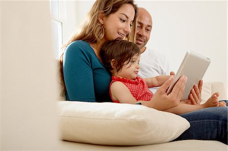 simsearch:614-09038547,k - Baby girl sitting on sofa with parents looking at digital tablet Stock Photo - Premium Royalty-Free, Code: 649-08922876