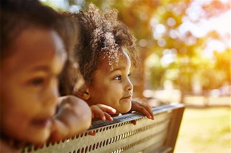 simsearch:649-07280848,k - Two young sisters looking peering over bench Photographie de stock - Premium Libres de Droits, Code: 649-08922922