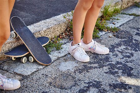 simsearch:649-08923565,k - Two female friends, standing outdoors, skateboards on floor beside them, low section Stock Photo - Premium Royalty-Free, Code: 649-08922945