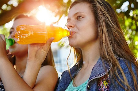 soft drinks - Two female friends sitting outdoors, drinking soft drinks Stock Photo - Premium Royalty-Free, Code: 649-08922954