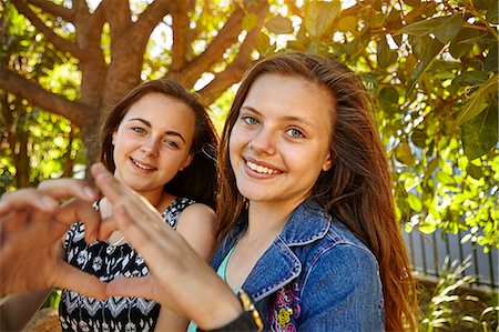 Portrait of two female friends in rural setting, making heart shape with hands Photographie de stock - Premium Libres de Droits, Code: 649-08922961