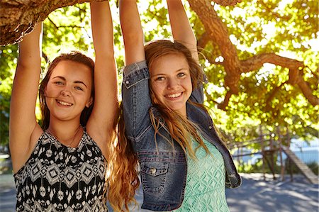 Portrait of two female friends outdoors, hanging on tree branch Stock Photo - Premium Royalty-Free, Code: 649-08922963