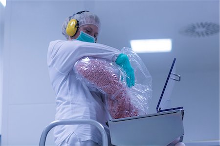 drugs factory - Worker pouring tablets into sorting machine  in pharmaceutical plant Photographie de stock - Premium Libres de Droits, Code: 649-08922999