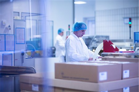 simsearch:649-08923012,k - Workers packaging pharmaceutical products on production line in pharmaceutical plant Photographie de stock - Premium Libres de Droits, Code: 649-08923010