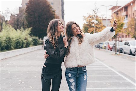 simsearch:649-08923048,k - Twin sisters, walking outdoors, taking selfie using smartphone Foto de stock - Royalty Free Premium, Número: 649-08923059