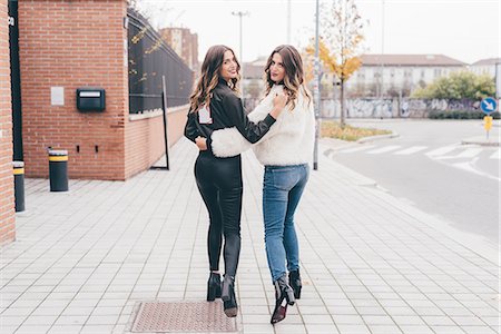 simsearch:649-08923050,k - Portrait of twin sisters, walking outdoors, looking over shoulder, smiling Stock Photo - Premium Royalty-Free, Code: 649-08923074