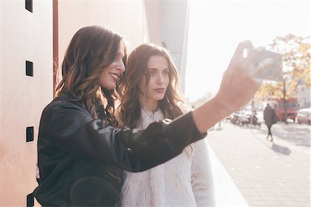 simsearch:649-08923050,k - Twin sisters, outdoors, taking selfie, using smartphone Stock Photo - Premium Royalty-Free, Code: 649-08923095