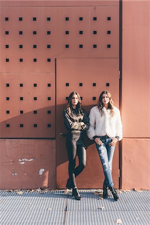 portrait of a young woman leaning on a wall - Portrait of twin sisters, outdoors, leaning against wall Stock Photo - Premium Royalty-Free, Code: 649-08923092