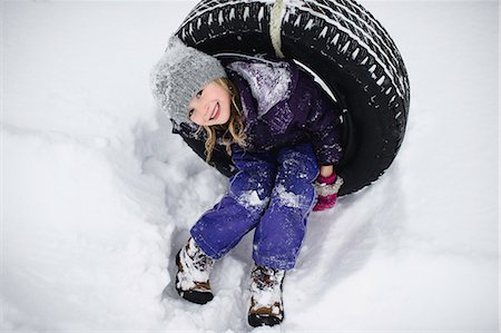 Overhead portrait of girl on tire swing in snow Fotografie stock - Premium Royalty-Free, Codice: 649-08923104