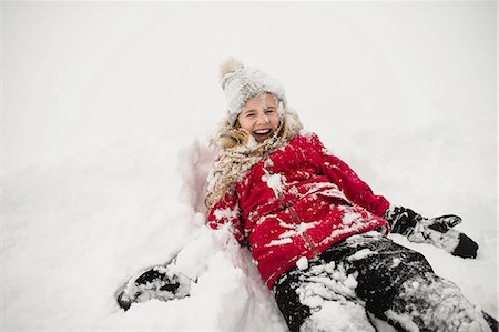 Smiling girl lying on back and covered in snow Fotografie stock - Premium Royalty-Free, Codice: 649-08923102