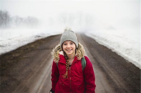 Portrait of girl in knit hat standing in middle of dirt road in fog Fotografie stock - Premium Royalty-Free, Codice: 649-08923131