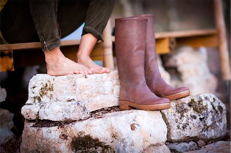 Mature woman's bare feet and knee high boots on stone porch steps Stock Photo - Premium Royalty-Free, Code: 649-08923225