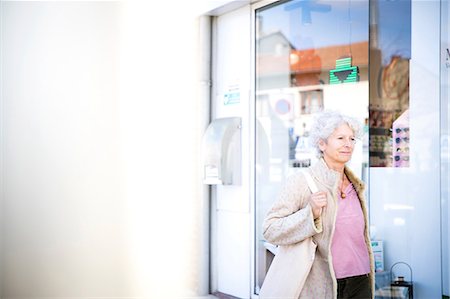 Mature woman shopper walking past local bank Fotografie stock - Premium Royalty-Free, Codice: 649-08923275