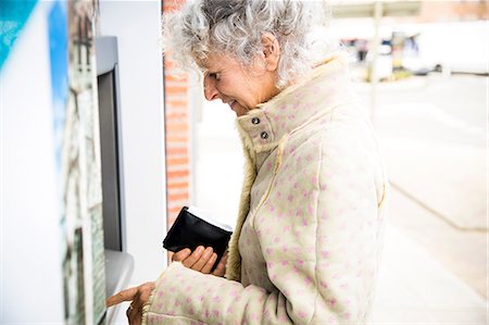 Mature woman pressing PIN at local french cash machine Foto de stock - Sin royalties Premium, Código: 649-08923283