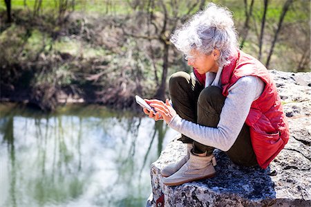 simsearch:6126-09103925,k - Woman sitting on rock texting on smartphone, Bruniquel, France Stock Photo - Premium Royalty-Free, Code: 649-08923324