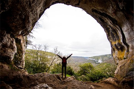 sobrecogimiento - Woman with arms raised at mouth of cave, Bruniquel, France Foto de stock - Sin royalties Premium, Código: 649-08923327