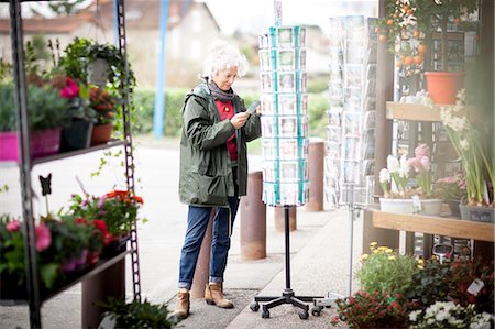 Woman looking at postcards, Bruniquel, France Stock Photo - Premium Royalty-Free, Code: 649-08923353