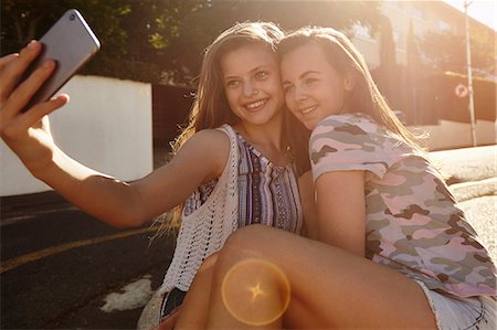 Teenage girls taking selfies in street, Cape Town, South Africa Stock Photo - Premium Royalty-Free, Code: 649-08923579
