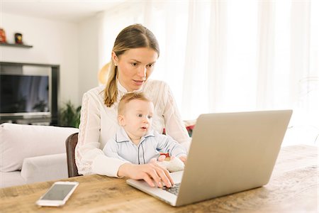 Mother working and caring for baby at home Stock Photo - Premium Royalty-Free, Code: 649-08923600