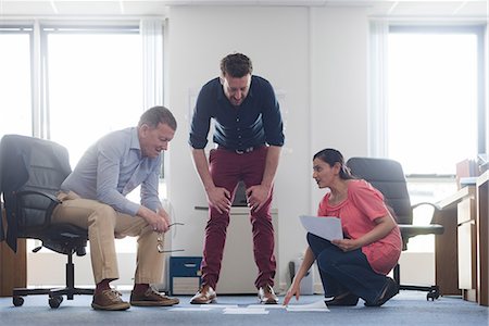 Colleagues discussing papers on office floor Stock Photo - Premium Royalty-Free, Code: 649-08923651