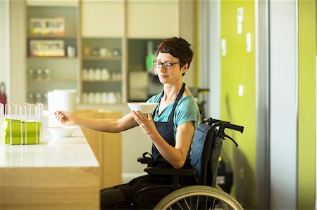 photo of person in wheelchair - Woman in wheelchair, working in restaurant, holding bowl of food Stock Photo - Premium Royalty-Free, Code: 649-08923720