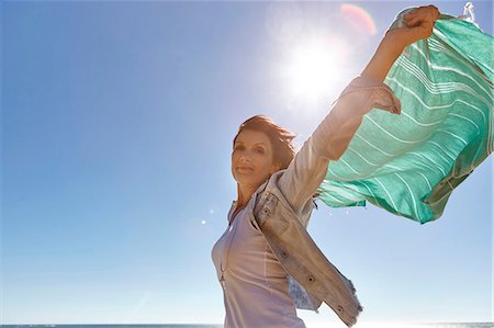 simsearch:649-08923733,k - Portrait of mature woman, outdoors, holding scarf up behind her to catch wind Photographie de stock - Premium Libres de Droits, Code: 649-08923738