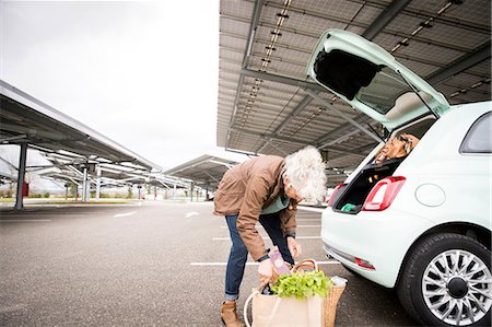 simsearch:649-08923766,k - Mature woman in car park, loading shopping into boot of car Foto de stock - Royalty Free Premium, Número: 649-08923764