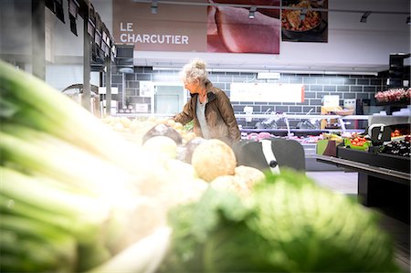 simsearch:400-06461903,k - Mature woman in supermarket, looking at fresh produce Foto de stock - Royalty Free Premium, Número: 649-08923768