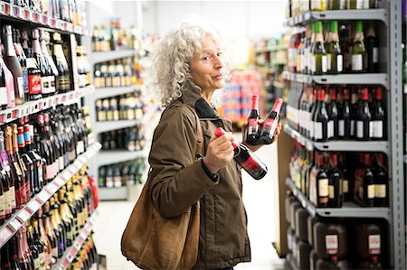 simsearch:400-06461903,k - Mature woman in supermarket, holding bottles of alcohol Foto de stock - Royalty Free Premium, Número: 649-08923778