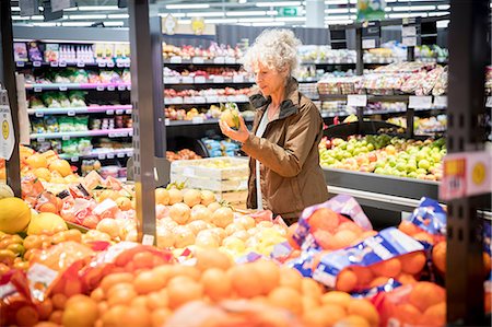simsearch:400-06461903,k - Mature woman in supermarket, looking at fresh produce Foto de stock - Royalty Free Premium, Número: 649-08923773