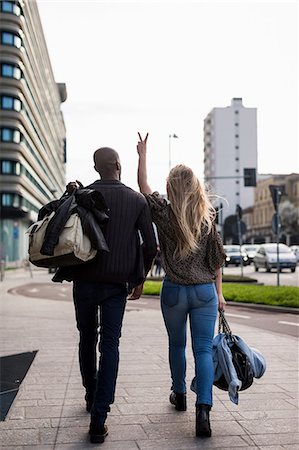 simsearch:649-08923913,k - Rear view of young couple making peace sign on city sidewalk Stock Photo - Premium Royalty-Free, Code: 649-08923914