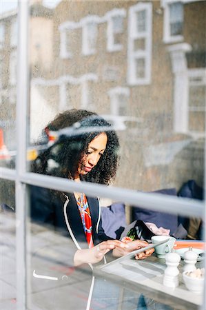 simsearch:649-08923947,k - Window view of woman using digital tablet in cafe Foto de stock - Sin royalties Premium, Código: 649-08923944