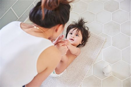 diapering mother to baby - Over shoulder view of woman playing with baby daughter's feet on bathroom floor Photographie de stock - Premium Libres de Droits, Code: 649-08949460