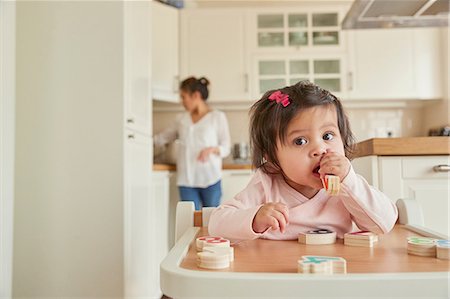 Baby girl chewing toy numerals on high chair Photographie de stock - Premium Libres de Droits, Code: 649-08949471