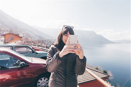 Mid adult woman taking smartphone selfie at lakeside, Monte San Primo, Italy Photographie de stock - Premium Libres de Droits, Code: 649-08949494