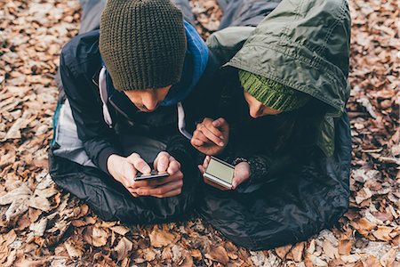 simsearch:649-08949526,k - Hiking couple lying in sleeping bags looking at smartphones in forest, Monte San Primo, Italy Photographie de stock - Premium Libres de Droits, Code: 649-08949550