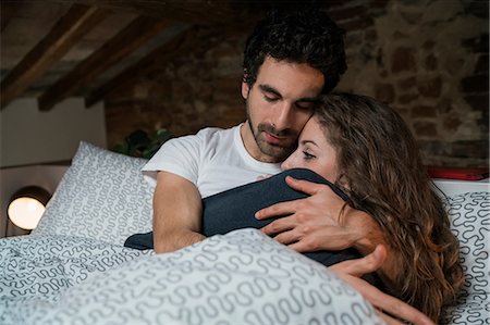 simsearch:649-08949562,k - Romantic couple lying in bed hugging Stock Photo - Premium Royalty-Free, Code: 649-08949561