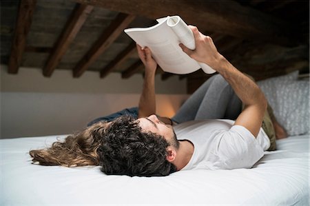 simsearch:649-08949562,k - Young couple lying on backs bed reading book together Stock Photo - Premium Royalty-Free, Code: 649-08949563