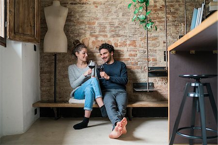 simsearch:649-08949589,k - Young couple raising a toast on kitchen bench Photographie de stock - Premium Libres de Droits, Code: 649-08949577