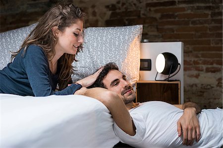 Affectionate young couple reclining on bed Stock Photo - Premium Royalty-Free, Code: 649-08949581