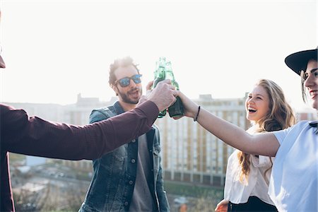 simsearch:649-08949687,k - Group of friends enjoying roof party, holding beer bottles, making toast Stock Photo - Premium Royalty-Free, Code: 649-08949668