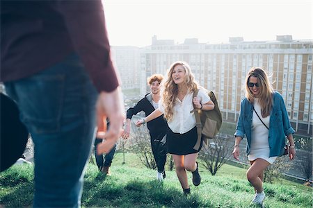 simsearch:649-08949675,k - Group of friends running up hill on roof party Foto de stock - Sin royalties Premium, Código: 649-08949663